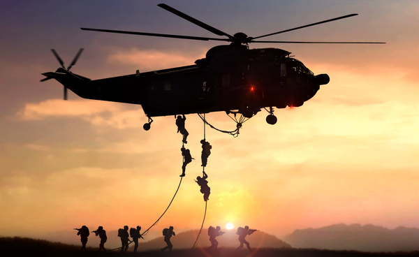Description: a group of soldiers are being pulled up by a helicopter.